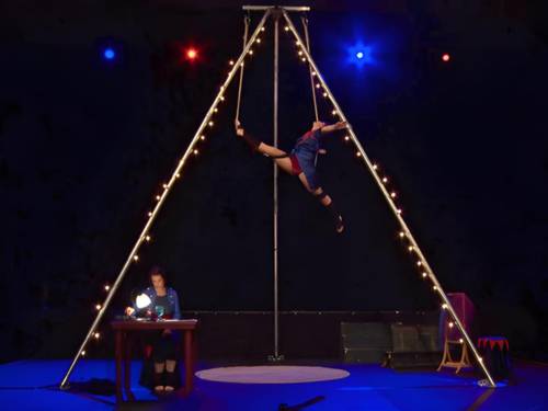 In Zirkusatmosphäre turnen zwei Zirkusartistinnen an einem Trapez.